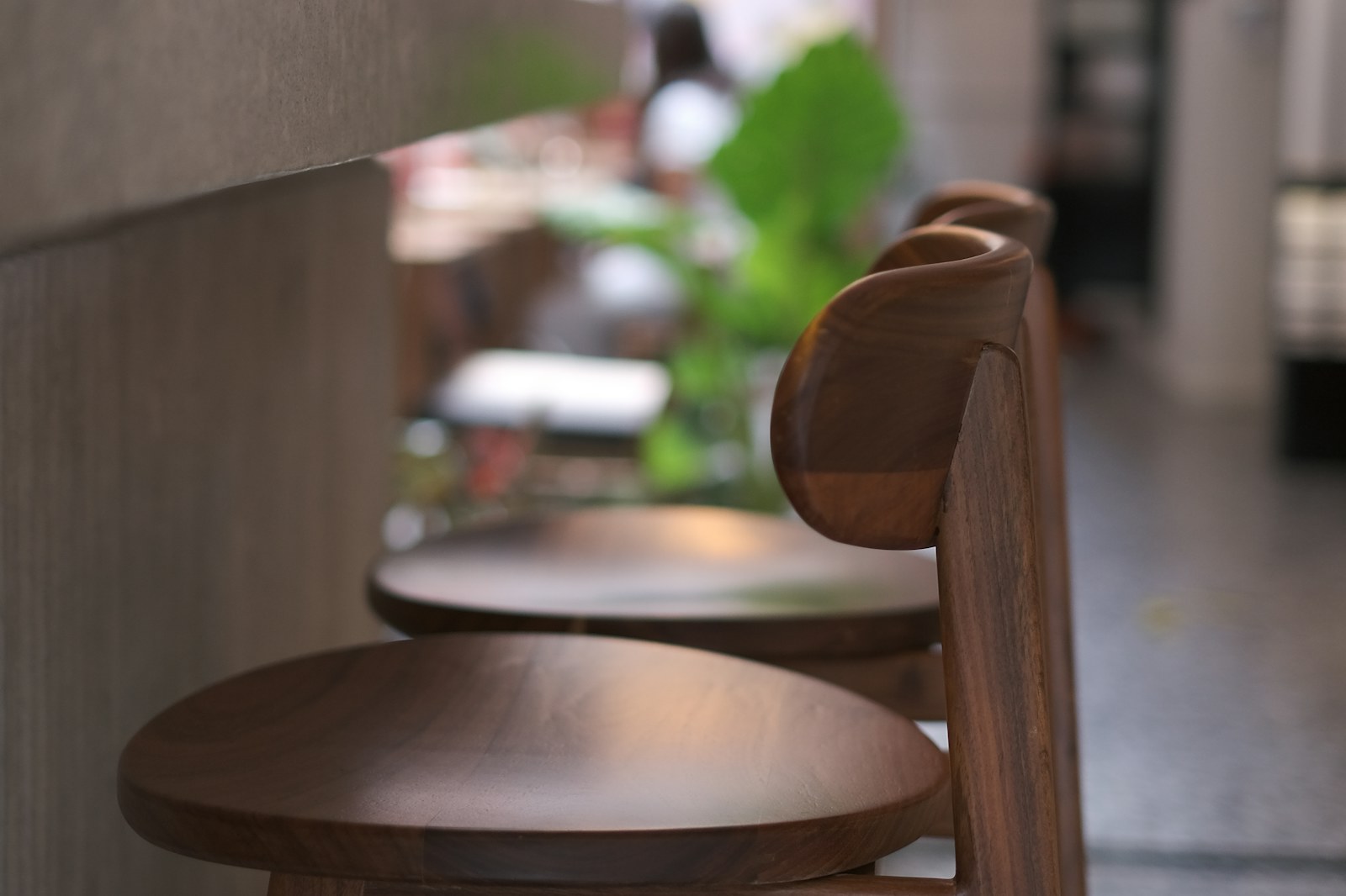 Tabourets en bois alignés dans un café aux tons chauds